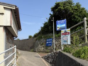 大王埼灯台へ続く細い坂道の途中にある八幡さん公園の案内看板