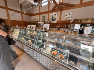 津市の高虎ドッグのショーケース前で商品を選ぶ女性客